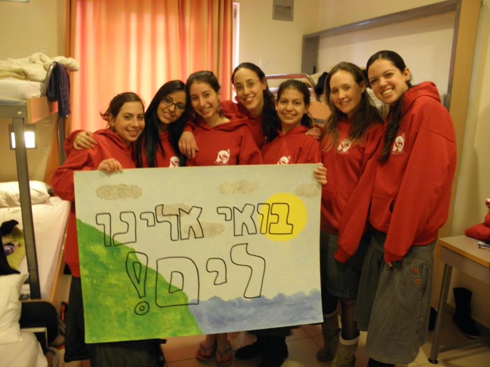 k_hiztarfilgarinmshpahotbhifa בנות שירות של גרעין הדר בתמונה עם קפוצ'ון של הגרעין ושלט "בואי אלינו לים"